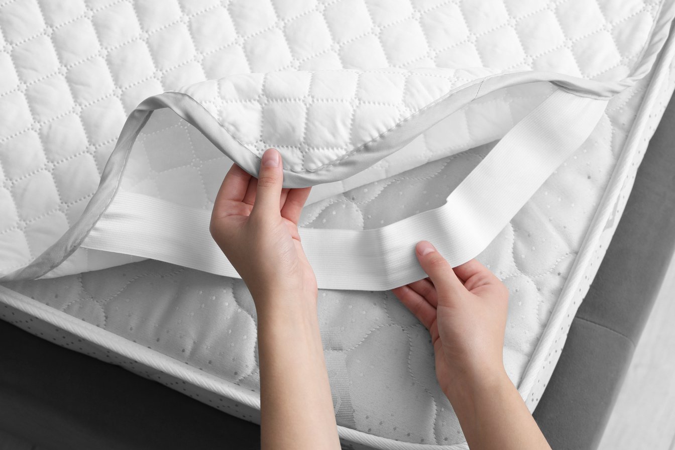 Woman Putting Protector on Mattress, Top View